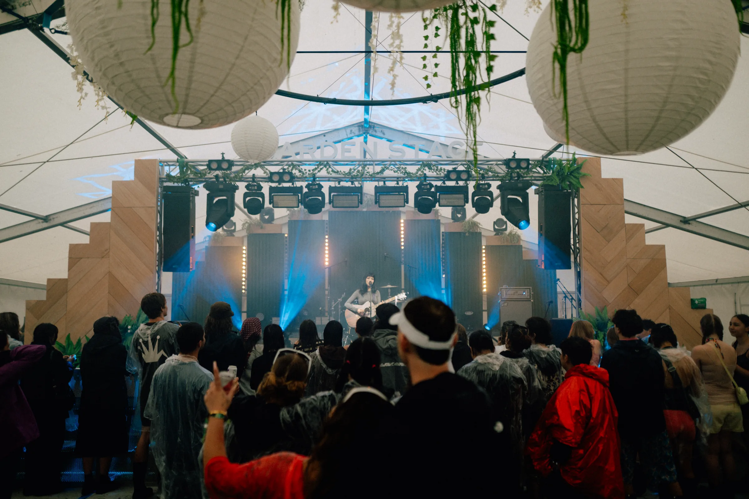 Crowd watching a live performance under the lit-up All Ears marquee stage